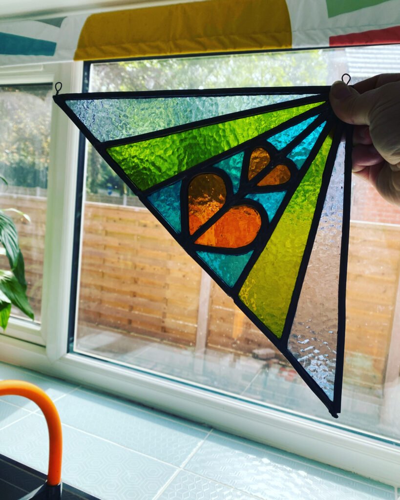 Stained glass that sits in the top corner of a window, displaying two hearts